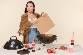 Young asian girl having problem with barbecue