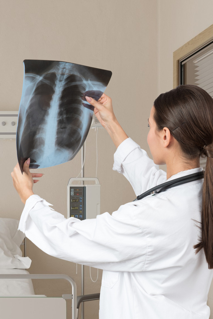 A  doctor examining an x-ray of a chest
