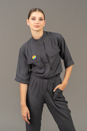 Front view of a young woman in a jumpsuit with lgbt pin