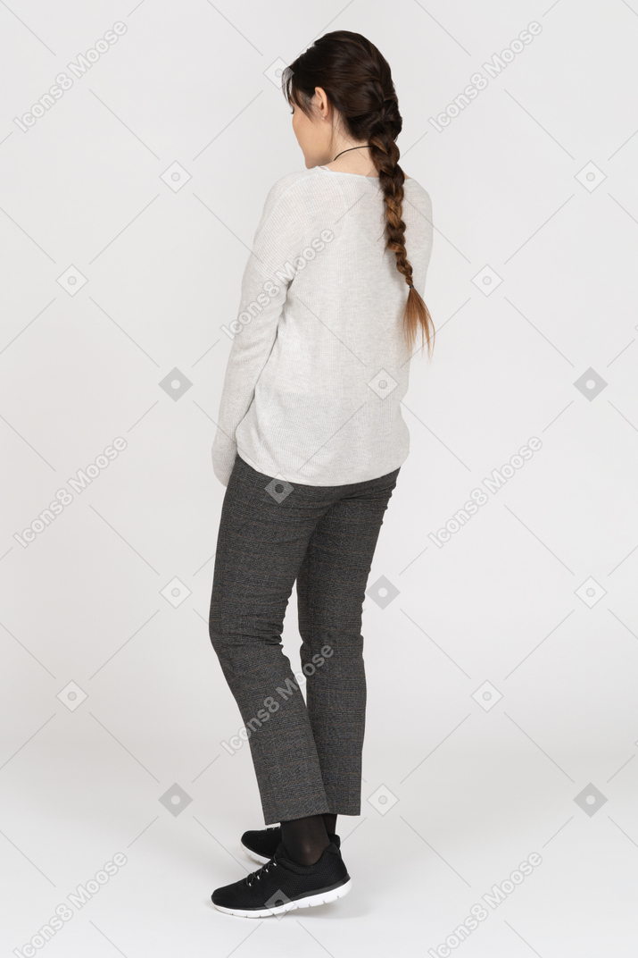 Slim caucasian female with long brown hair posing back to camera isolated over white background