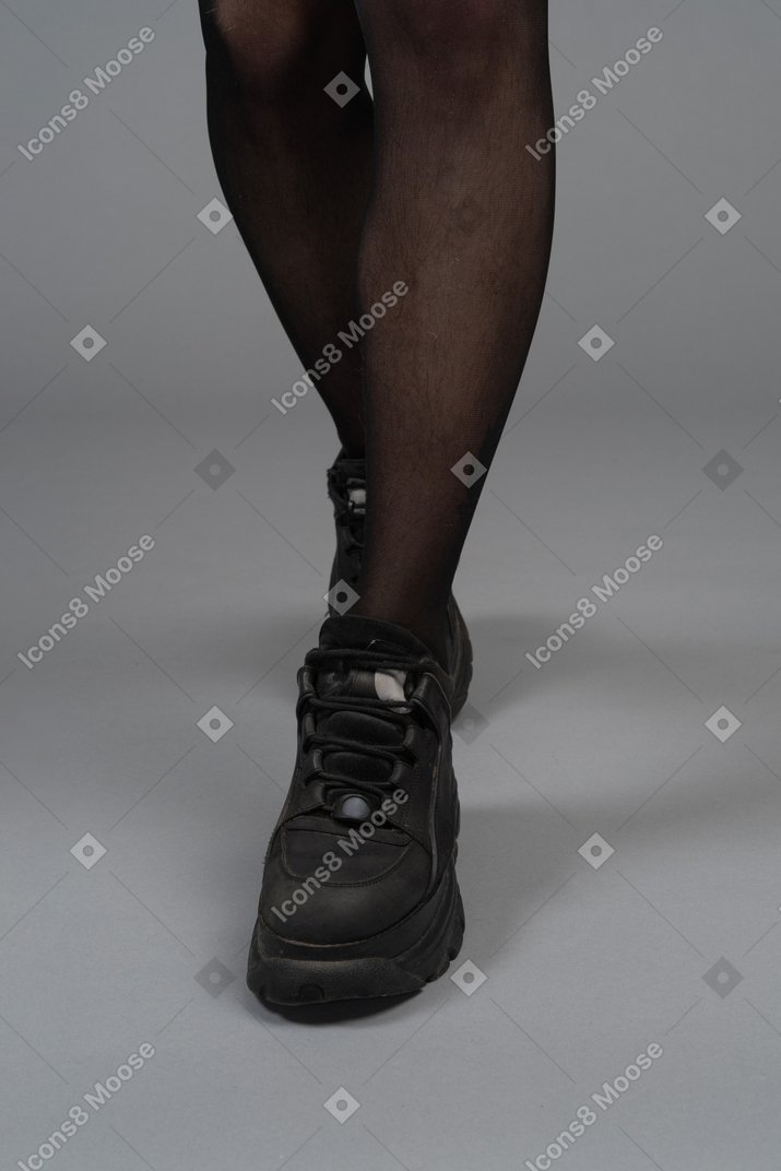 Close-up view of legs in black tights and boots