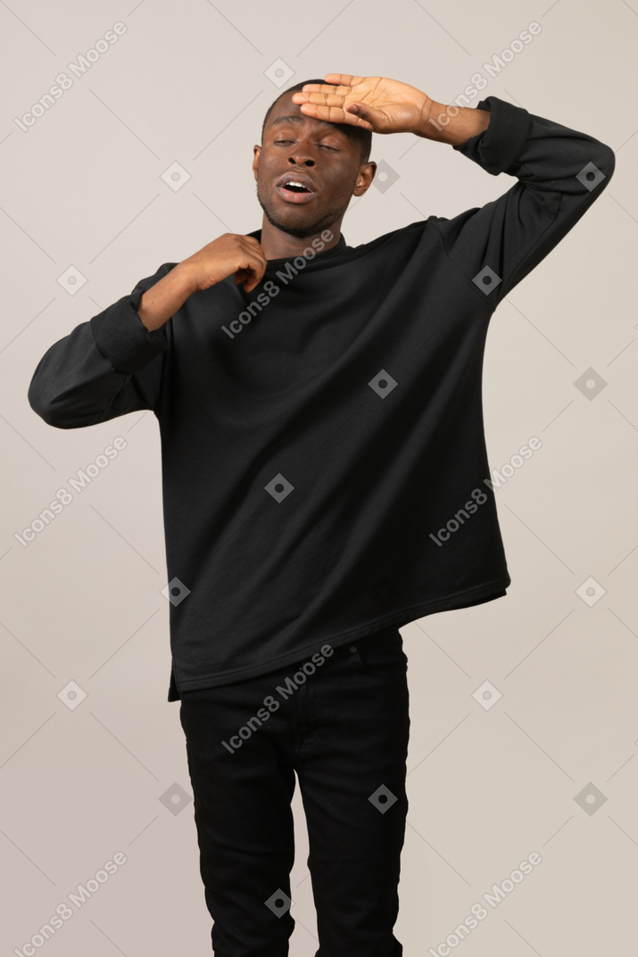 Young man touching his forehead to check body temperature
