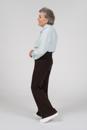 Vista laterale di una donna anziana che cammina