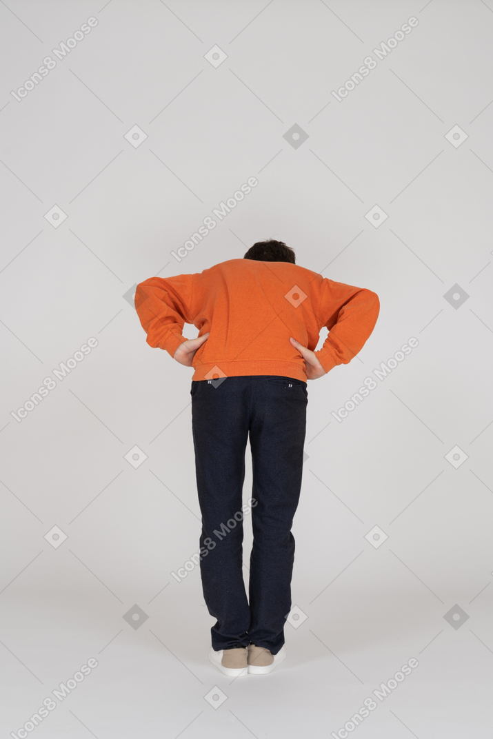 Jeune homme en sweat-shirt orange posant