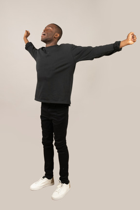 Young man standing with arms outstretched