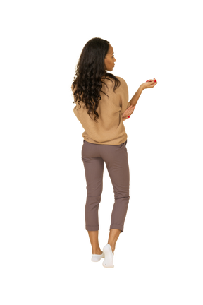 Back view of a dark-skinned questioning young female raising hand