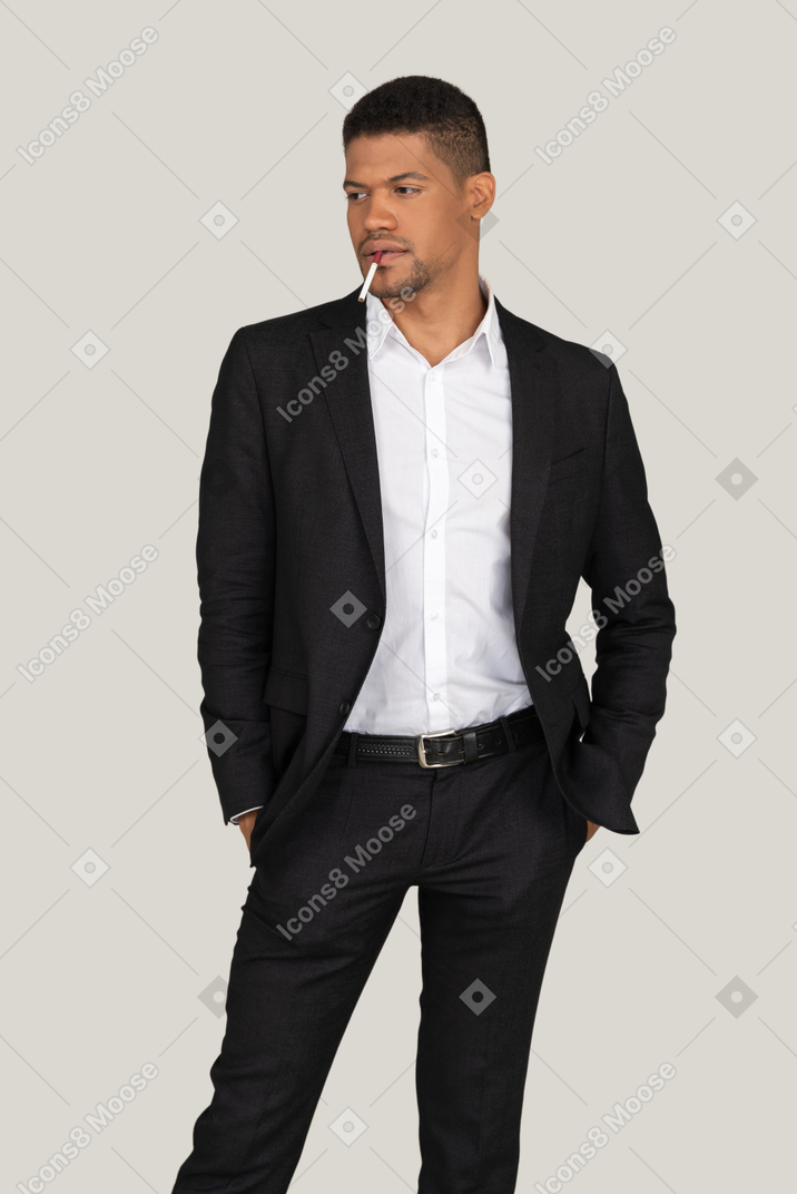 Young guy in a black suit smoking a cigarette