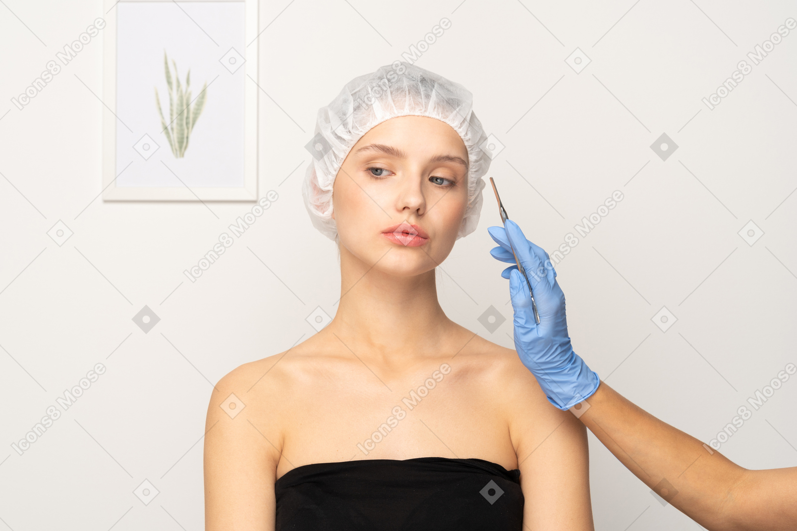 Doctor holding scalpel near female patient's face