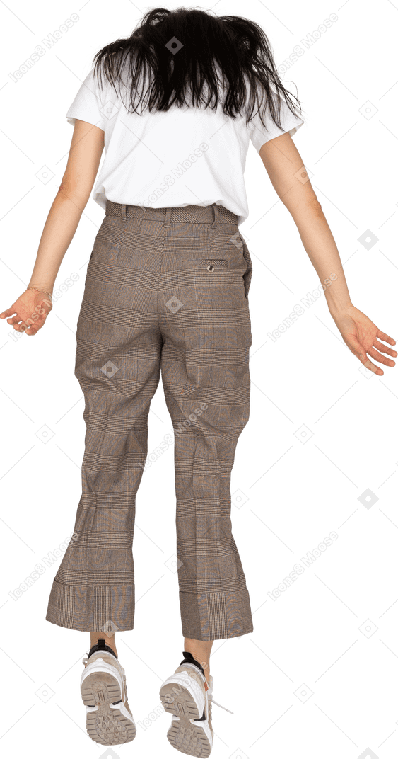 Vista traseira de uma jovem saltitante de calça e camiseta olhando para baixo