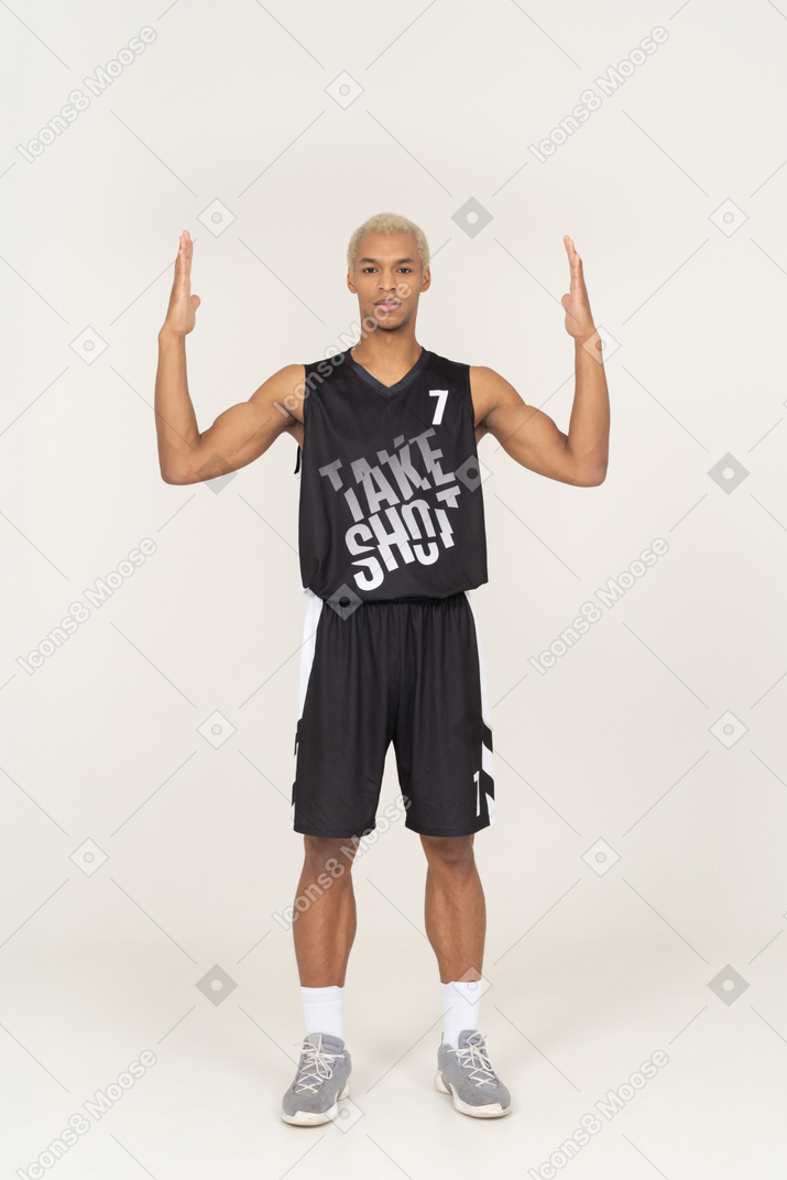 Vista frontal de um jovem jogador de basquete levantando as mãos