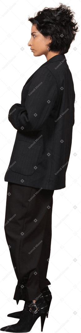 Vista lateral de uma mulher de negócios séria em um terno preto olhando furiosamente de lado