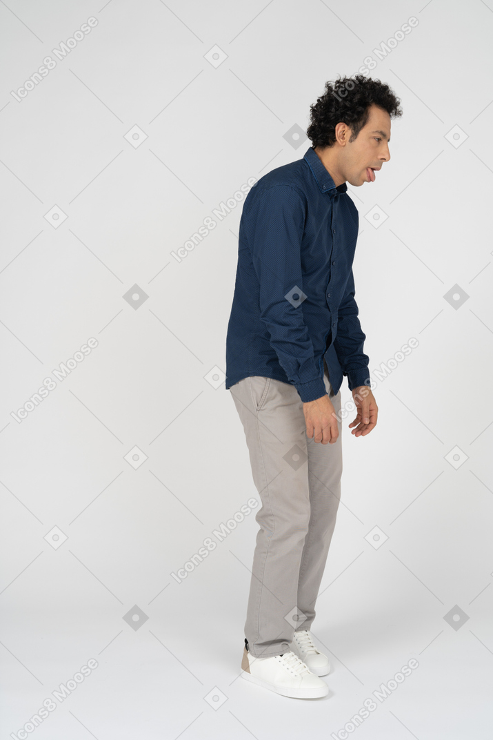 Side view of a man in casual clothes making faces