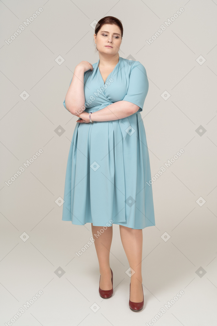 Женщина в синем платье думает, вид спереди