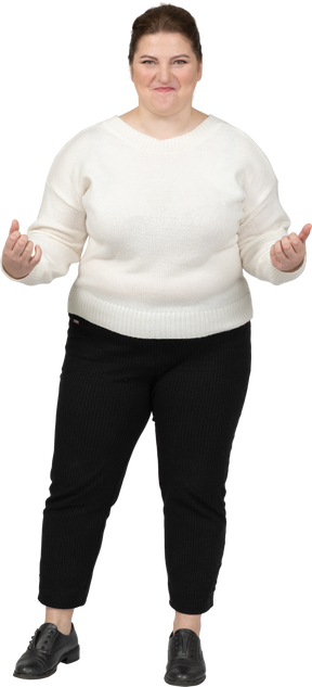 Plus size woman in white sweater looking at camera