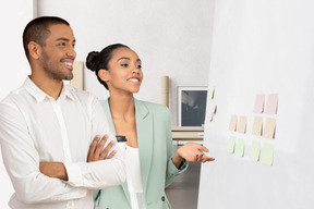 Two people standing in front of a whiteboard