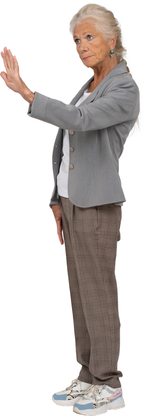 Vista lateral de una anciana en traje mostrando gesto de parada