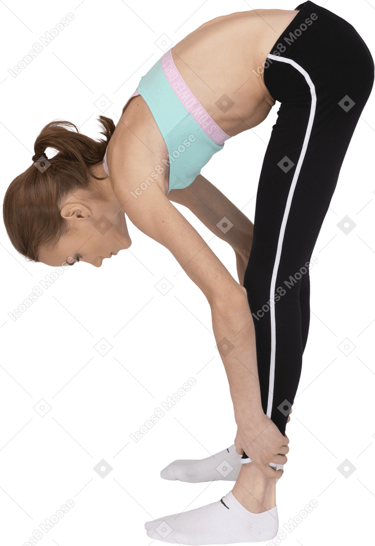 Side view of a teen girl in sportswear stretching while holding ankles