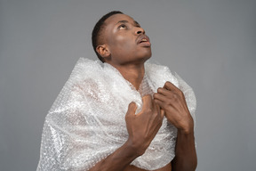 Close-up an african male in plastic wrap standing in religious pose