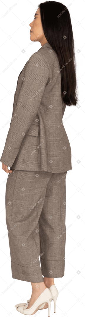 Three-quarter back view of a young lady in brown business suit closing her eyes