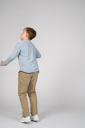 Back view of a boy in casual clothes standing