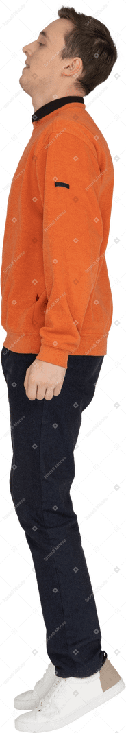 Young man in orange sweatshirt jumping