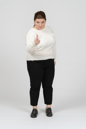 Vista frontale di una donna grassoccia in abiti casual che indica con un dito