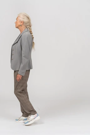 Side view of an old lady in suit walking