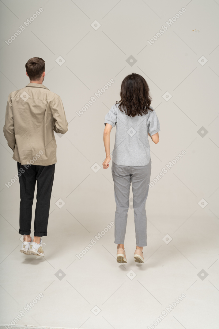 Vista traseira do jovem e da mulher levitando