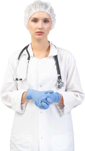Vista frontal de una joven doctora cansada con estetoscopio tomados de la mano juntos