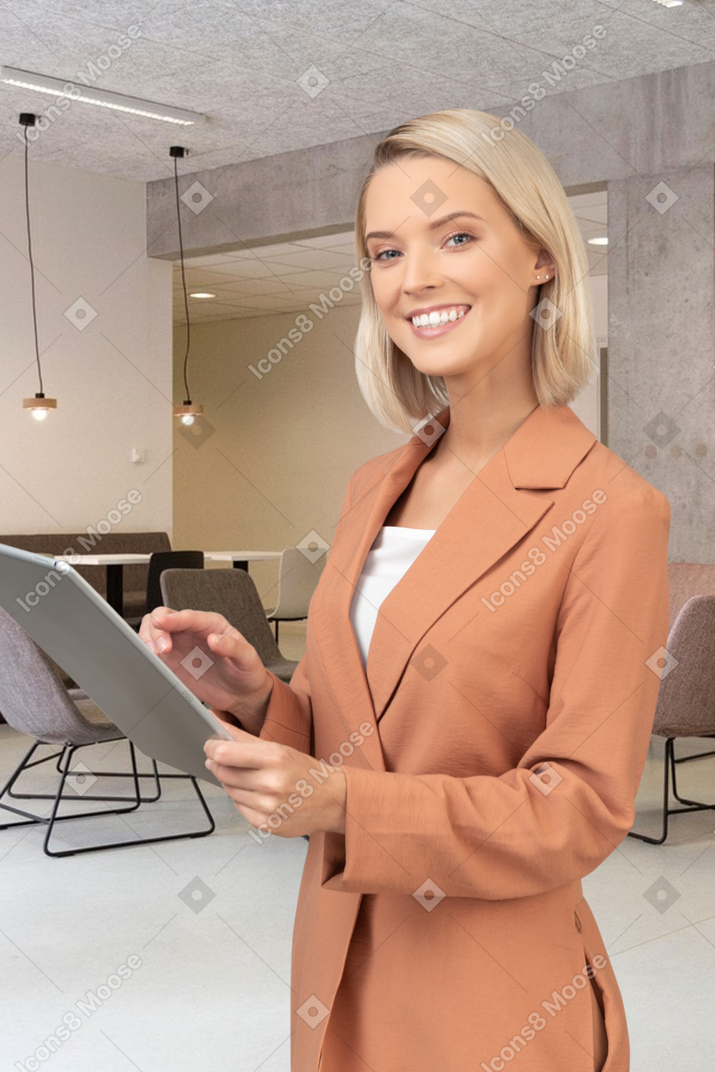 A woman standing in a room holding a tablet