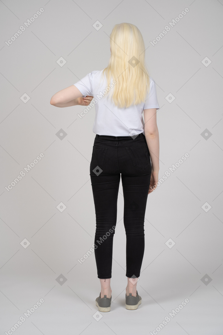 Young blonde girl standing back to camera