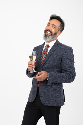 Man in suit with wide smile on his face holding a glass