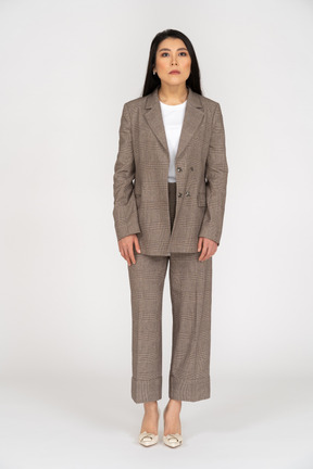Front view of a speechless young lady in brown business suit