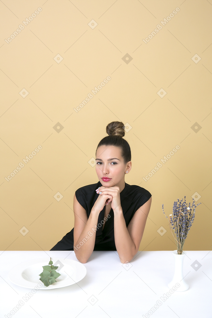Elegant young woman sitting at the table