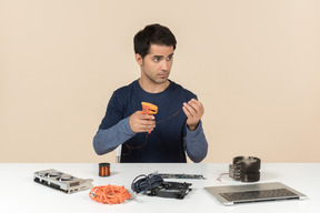 A young man in casual blue clothes working with computer details