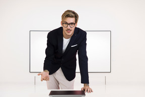A man in a suit leaning over a laptop