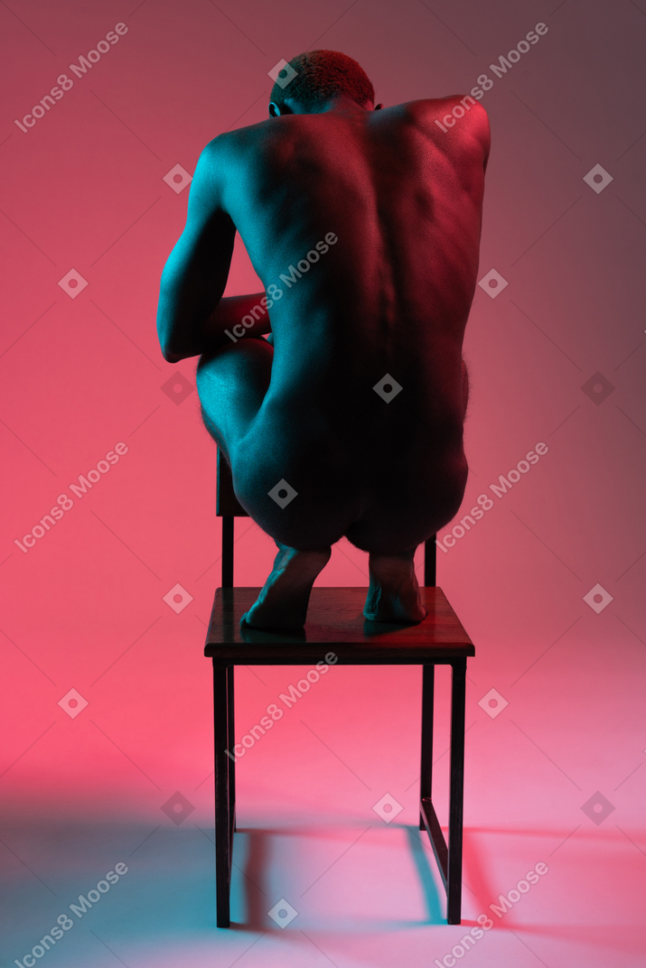 Young black man standing on chair