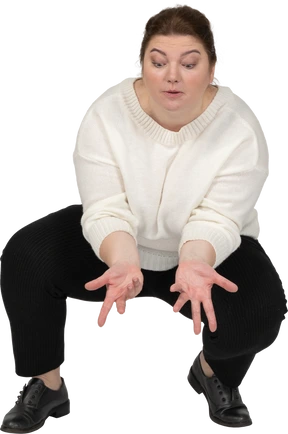 Front view of a plus size woman in casual clothes squatting