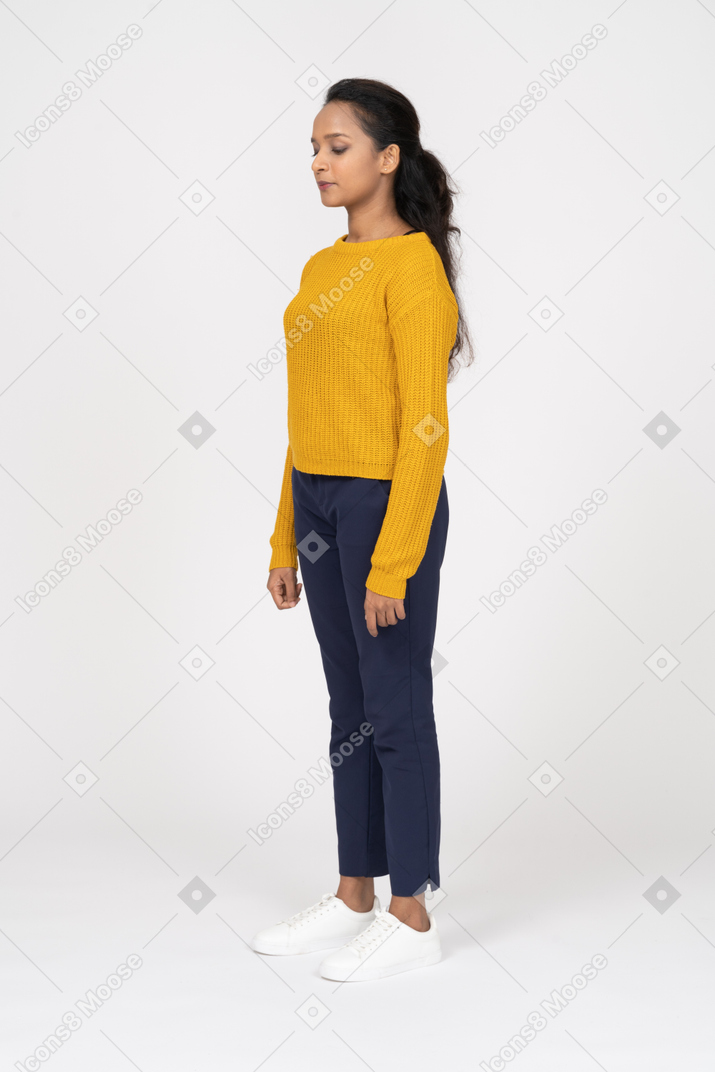 Side view of a girl in casual clothes standing with closed eyes