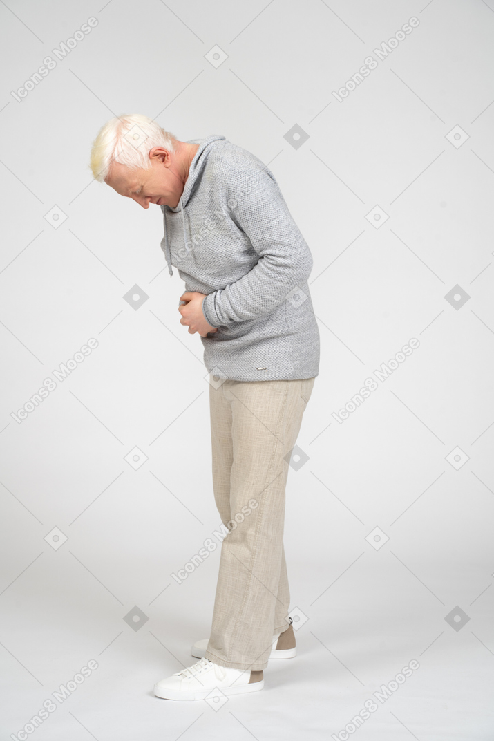 Homem de meia idade com as mãos no estômago, sofrendo de dor abdominal