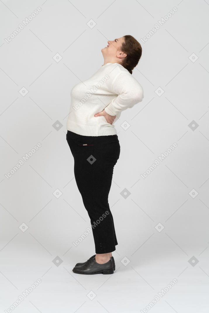 Plus size woman in casual clothes suffering from pain in lower back