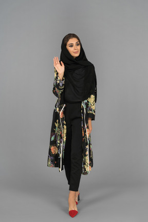 Femme musulmane couverte en agitant avec une main