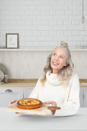 A woman sitting at a table with a pie in front of her