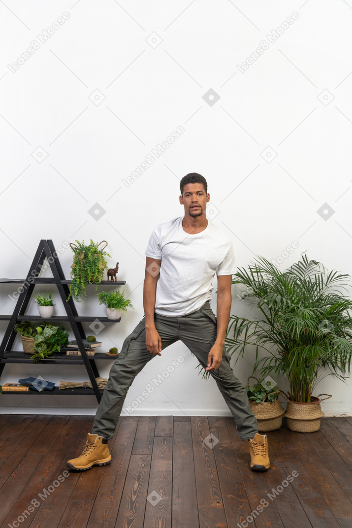 Handsome athletic man posing on the background of the apartment