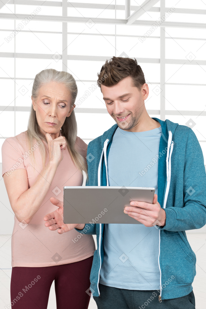 A man and woman looking at a tablet