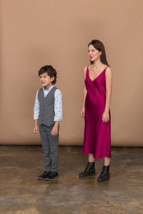 Side view of a young woman in red dress and boy