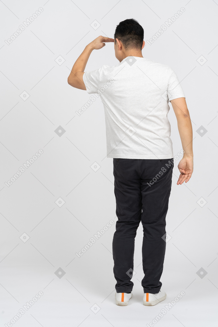Rear view of a man in casual clothes looking for someone