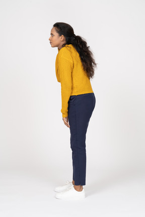 Side view of a serious girl in casual clothes staring at something