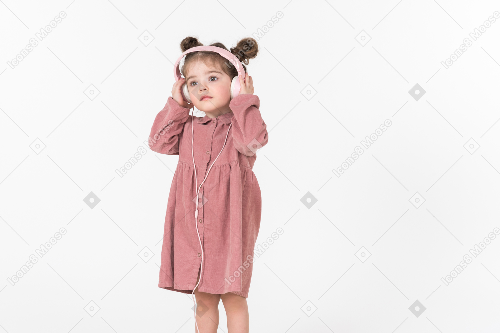 Little kid girl listening to music in headphones