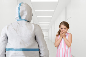 Scared girl looking at person in protective suit